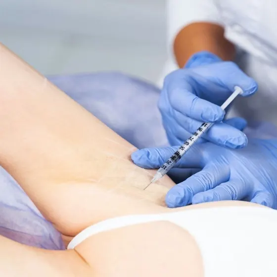 Woman receiving underarm sweating treatment